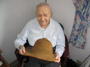 Major Barre pictured circa 2003 holding  a pith helmet signed by his uncle, Major Hercule Barre, in 1914. 