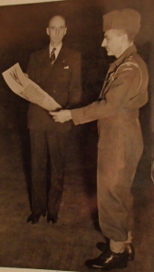 LCol (ret'd) Slessor presenting a scroll to LCol Brewer (wearing battle dress)