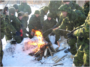 Members of The Royal Montreal Regiment cooking sausages over an open-air fire at the end of exercise Lynx Polaire in CFB Farnham early January 2016. Photo: Capt M.J. Szostak, RMR UPAR.